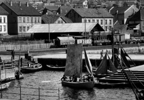 Byprospekt, bebyggelse, Larvik, sjøsiden, jernbanen, Storgata med Festiviteten og Thora Hansens hotell, småbåter på havnen, noen med seil.
